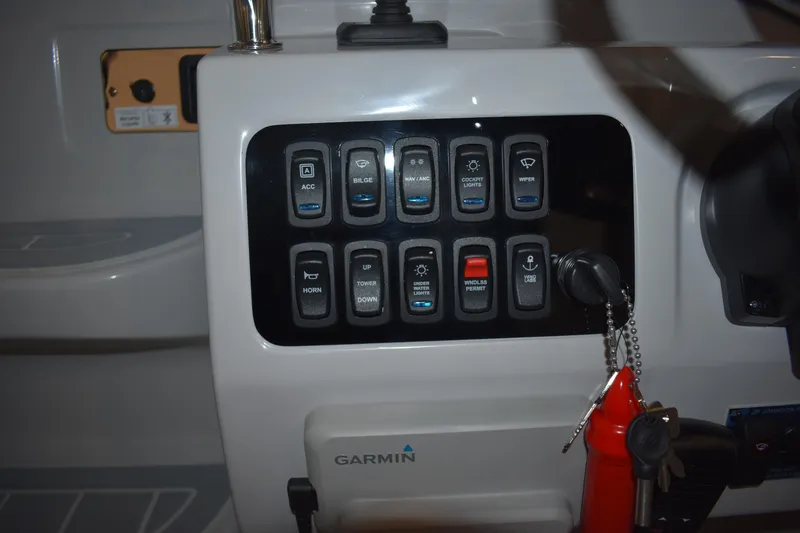 Slide: The Image of Control panel of 2026 Regal 26 XO boat with labeled switches and Garmin device. - 21