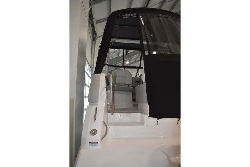 Slide: The Image of 2026 Regal 26 XO boat with black canopy in indoor storage. - 3