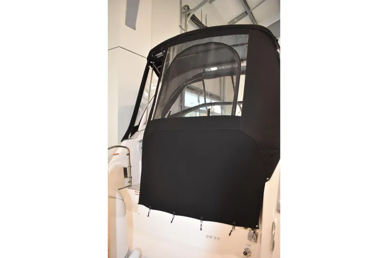 Slide: The Image of 2026 Regal 26 XO boat with black canvas cover in a showroom setting. - 4