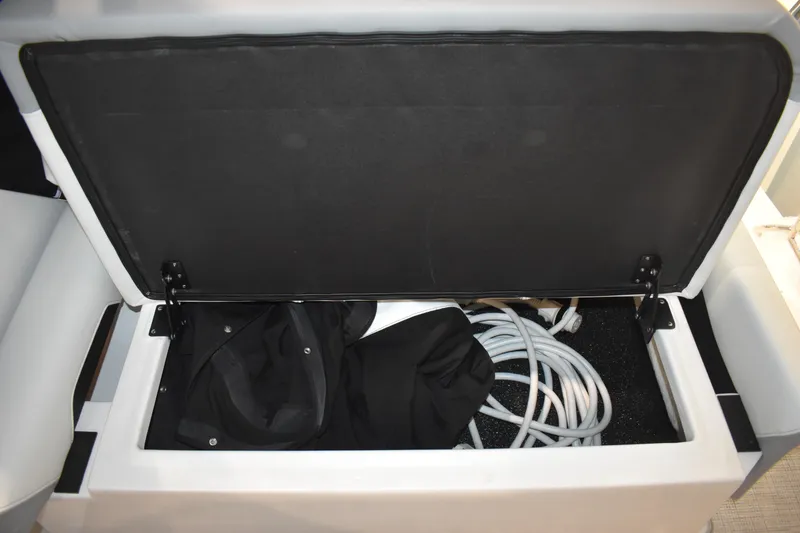 Slide: The Image of Open storage compartment on 2026 Regal 26 XO boat with coiled cables and fabric. - 8