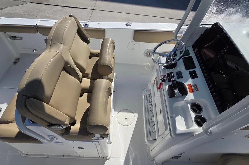 Slide: The Image of 2018 Sea Hunt Gamefish 27 boat interior with beige seating and control panel. - 11