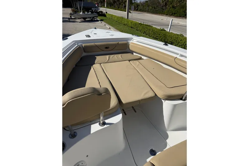 Slide: The Image of 2018 Sea Hunt Gamefish 27 boat interior with tan cushioned seating. - 13