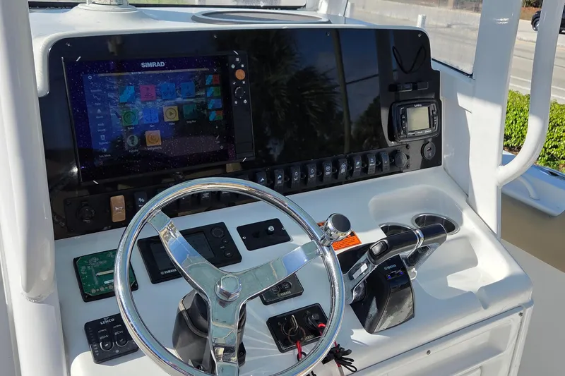 Slide: The Image of 2018 Sea Hunt Gamefish 27 dashboard with steering wheel and navigation controls. - 14