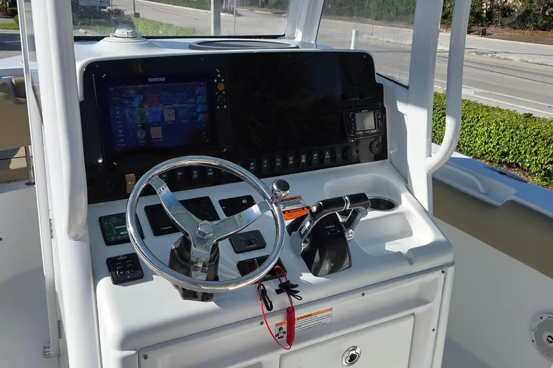 Slide: The Image of 2018 Sea Hunt Gamefish 27 helm with steering wheel and navigation controls. - 15