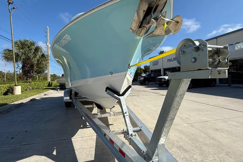 Slide: The Image of 2018 Sea Hunt Gamefish 27 boat on trailer, sunny day, palm trees in background. - 17