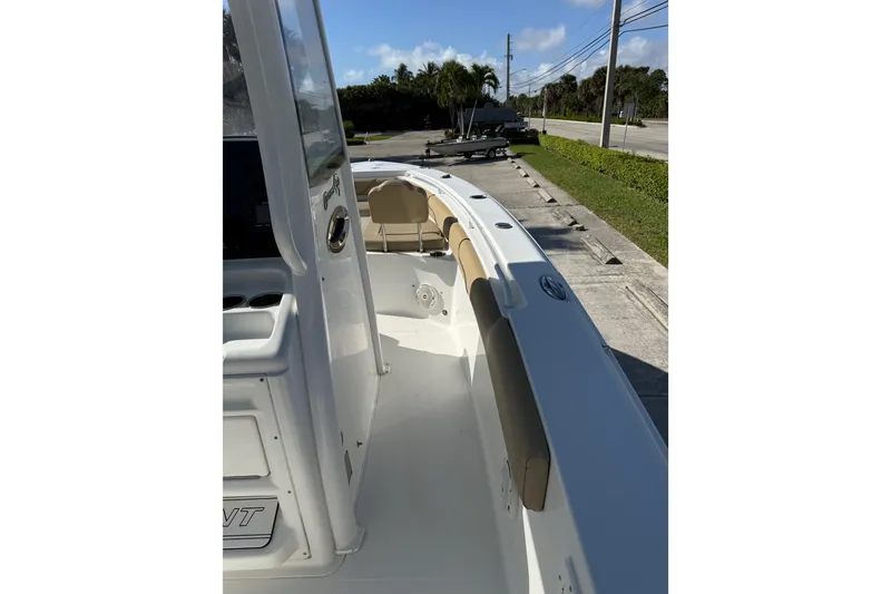 Slide: The Image of 2018 Sea Hunt Gamefish 27 boat interior with seating and console, parked on a sunny day. - 23