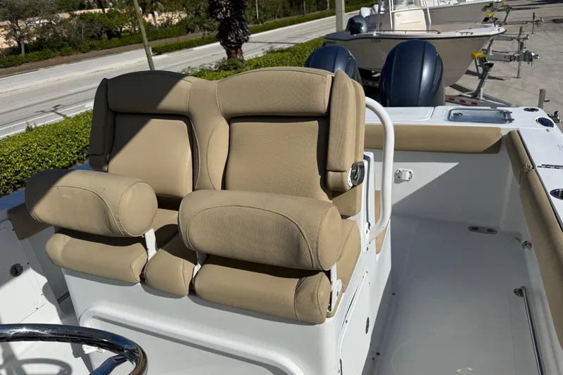 Slide: The Image of 2018 Sea Hunt Gamefish 27 boat with beige cushioned seating and dual outboard motors. - 29