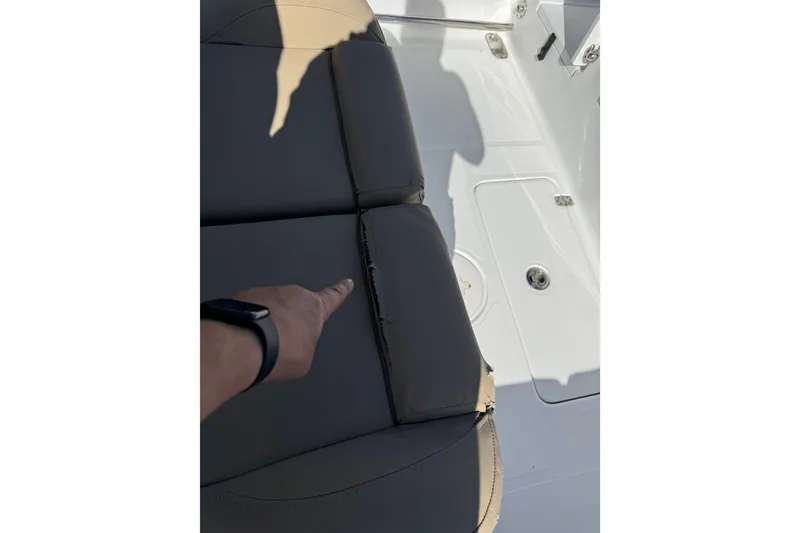 Slide: The Image of 2018 Sea Hunt Gamefish 27 boat seat with visible tear and pointing hand. - 33