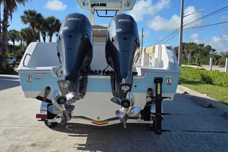 Slide: The Image of 2018 Sea Hunt Gamefish 27 boat with dual outboard engines, parked on a sunny day. - 6