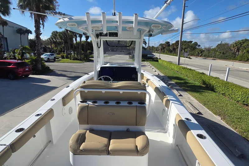 Slide: The Image of 2018 Sea Hunt Gamefish 27 boat with seating, parked near palm trees and road. - 7