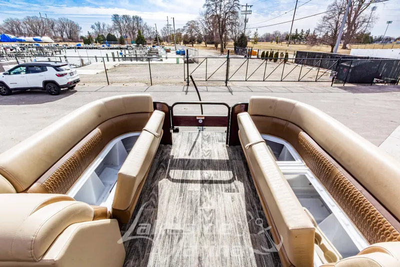 Slide: The Image of 2023 Godfrey Sweetwater 2286 FS pontoon boat interior with tan seating and open storage compartments. - 14