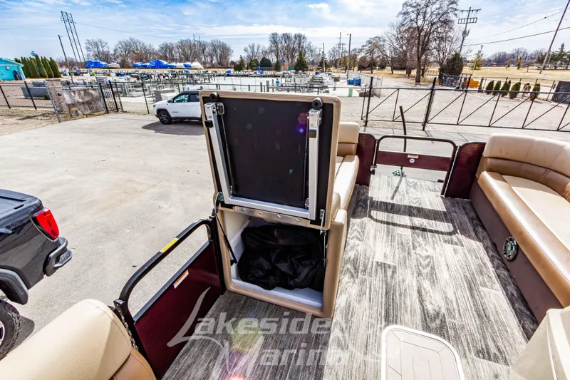 Slide: The Image of 2023 Godfrey Sweetwater 2286 FS pontoon boat with open storage compartment, docked outdoors. - 15
