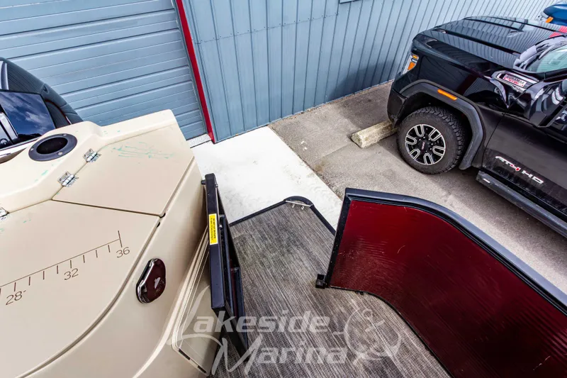 Slide: The Image of 2023 Godfrey Sweetwater 2286 FS pontoon boat near a black truck in a parking area. - 33