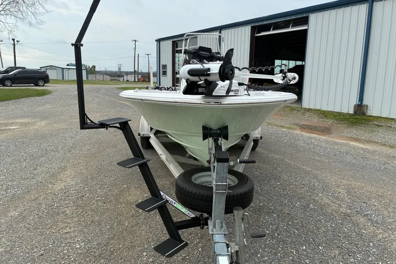 Slide: The Image of 2020 Sportsman Tournament 214 SBX Bay Boat on trailer, parked outside a metal building. - 3