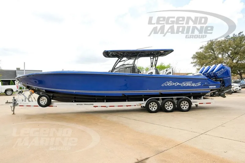 Slide: The Image of 2023 Nor-Tech 390 Sport Center Console boat on trailer, vibrant blue finish. - 12