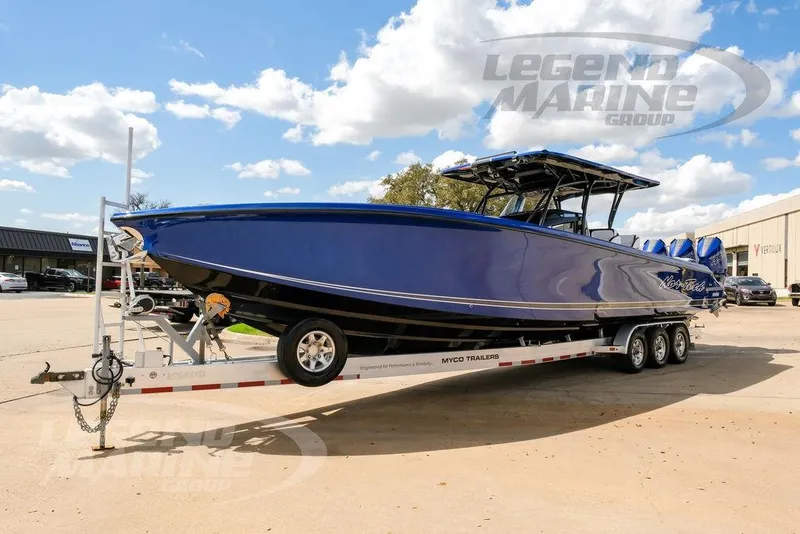 Slide: The Image of 2023 Nor-Tech 390 Sport Center Console boat on trailer under blue sky. - 5
