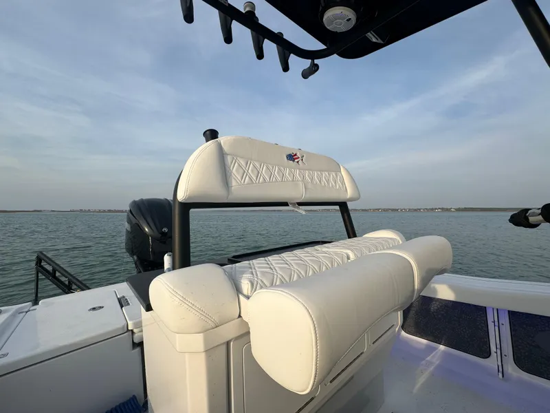 Slide: The Image of 2025 Crevalle 24 HCO boat with white seating, on calm water. - 35