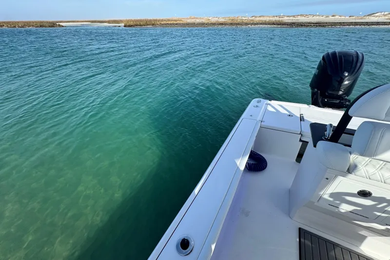 Slide: The Image of Crevalle 24 HCO 2025 boat on clear blue water near a sandy shoreline. - 43