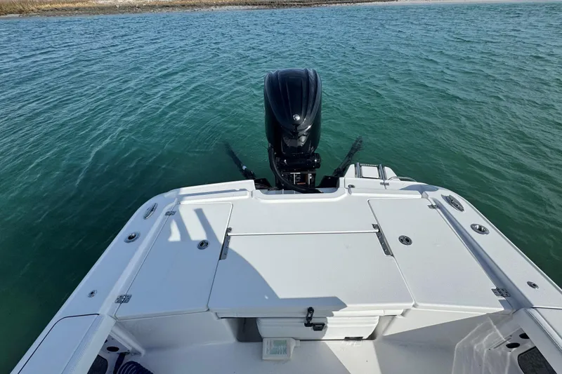 Slide: The Image of 2025 Crevalle 24 HCO boat stern view with outboard motor on calm water. - 44