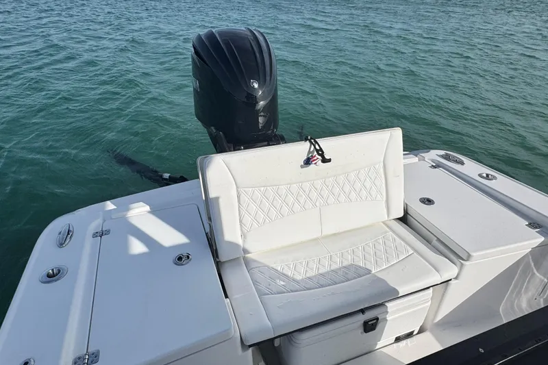 Slide: The Image of 2025 Crevalle 24 HCO boat with white seating and outboard motor on water. - 45