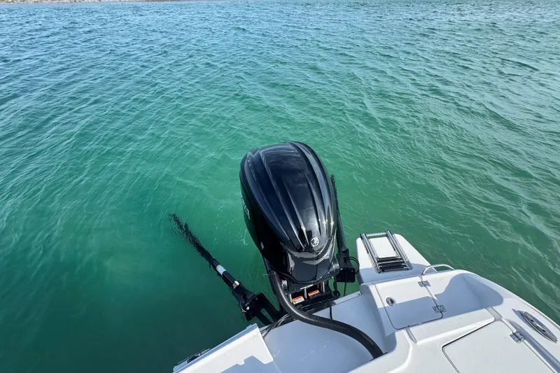 Slide: The Image of 2025 Crevalle 24 HCO boat with outboard motor on clear turquoise water. - 46