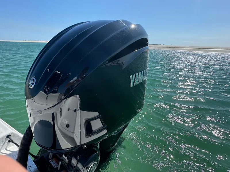 Slide: The Image of Outboard motor on a 2025 Crevalle 24 HCO boat in clear blue water. - 50