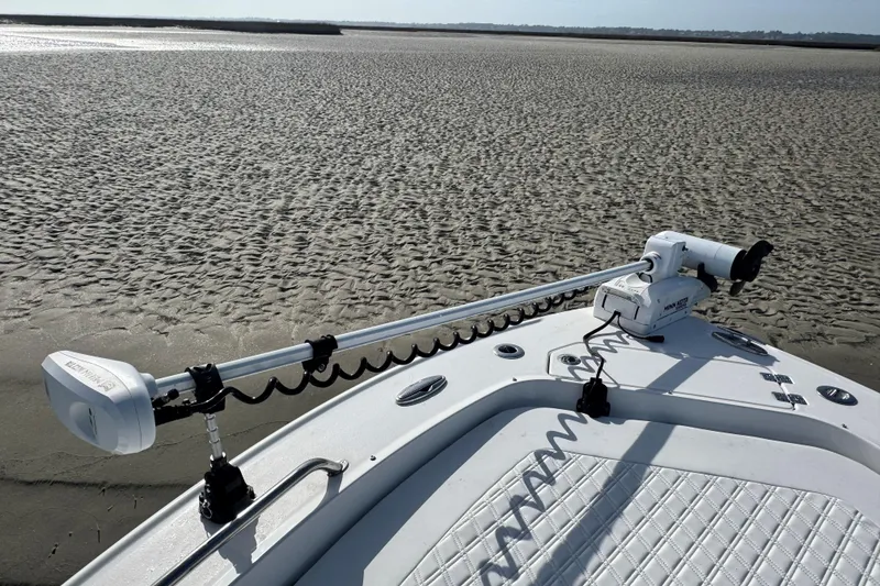 Slide: The Image of 2025 Crevalle 24 HCO boat with trolling motor on sandy shore. - 9
