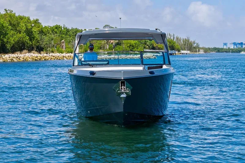 Slide: The Image of 2022 Aviara AV40 OB boat cruising on a sunny day, surrounded by lush greenery. - 7