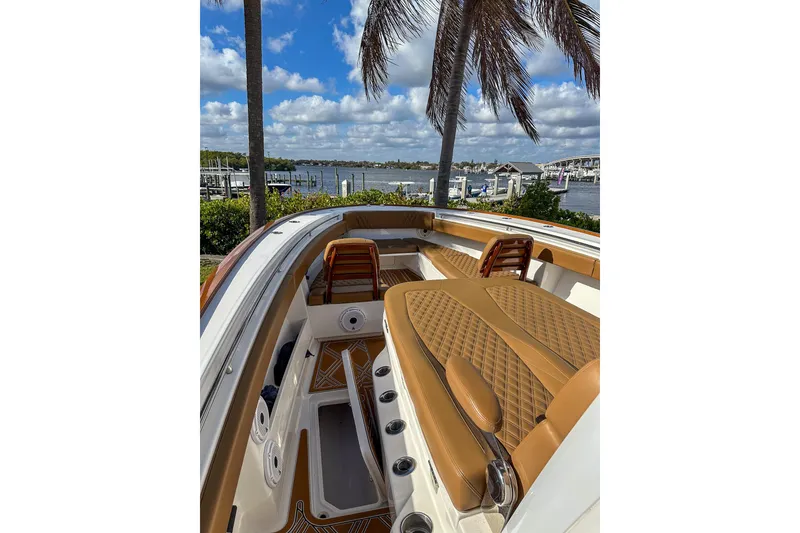 Slide: The Image of 2022 Invincible 39 Open Fisherman boat with luxurious seating, docked by a scenic waterfront. - 11