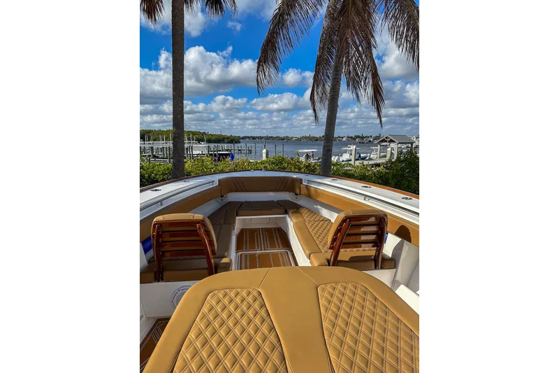 Slide: The Image of 2022 Invincible 39 Open Fisherman boat with luxurious seating, docked by a scenic waterfront. - 15