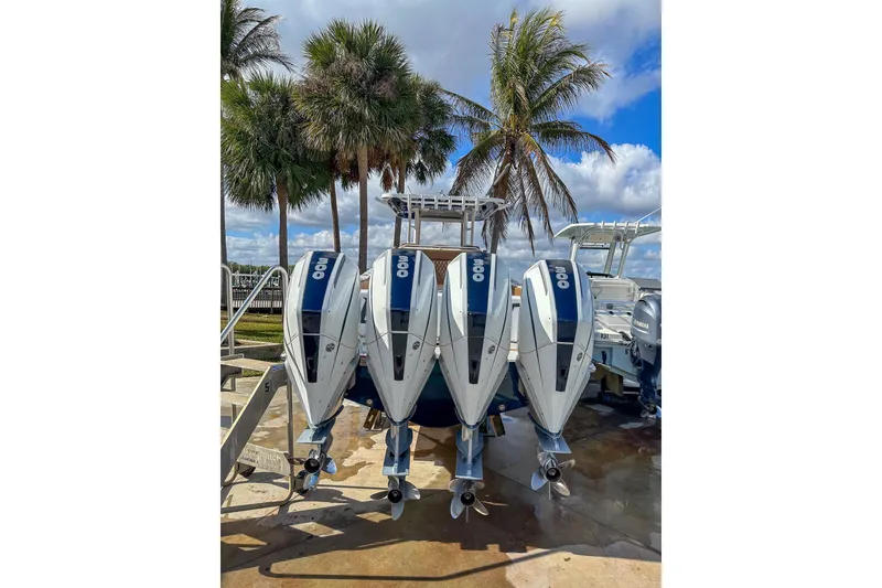 Slide: The Image of 2022 Invincible 39 Open Fisherman with quad outboard engines, palm trees in background. - 2