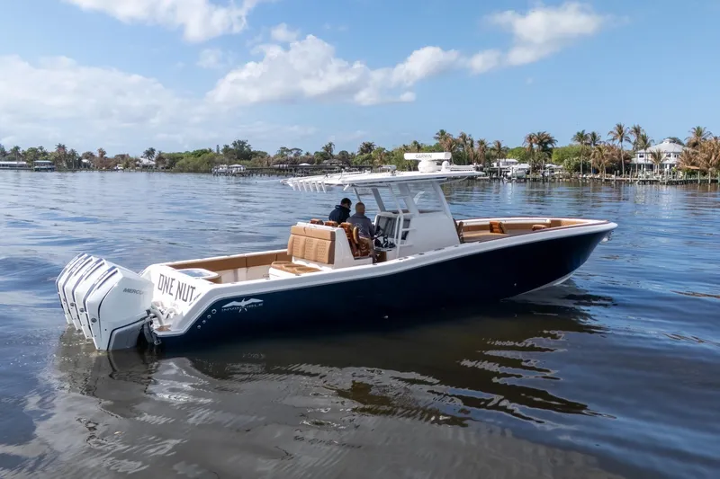 Slide: The Image of 2022 Invincible 39 Open Fisherman boat on calm water, featuring multiple outboard engines. - 33