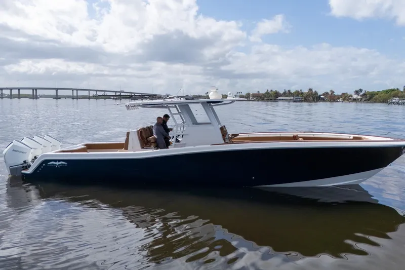Slide: The Image of 2022 Invincible 39 Open Fisherman boat on calm water, with bridge in background. - 34