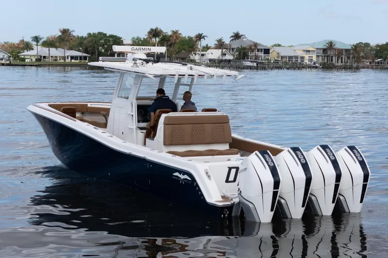 Slide: The Image of 2022 Invincible 39 Open Fisherman boat with four powerful outboard engines on calm water. - 39