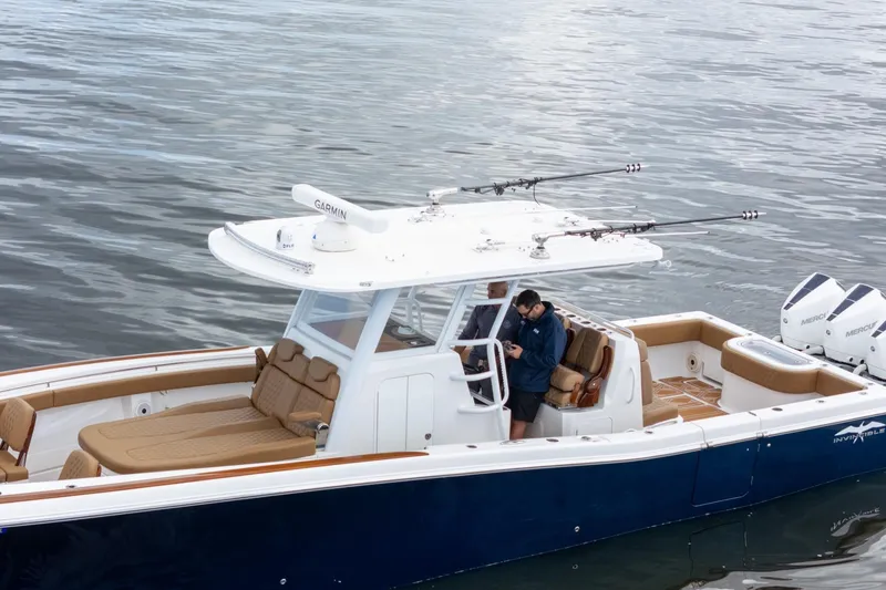 Slide: The Image of 2022 Invincible 39 Open Fisherman boat on water, featuring Garmin equipment and twin Mercury engines. - 42