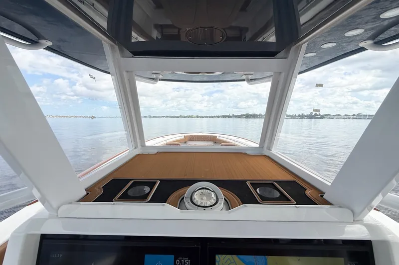 Slide: The Image of 2022 Invincible 39 Open Fisherman boat interior with navigation console, overlooking calm waters. - 52