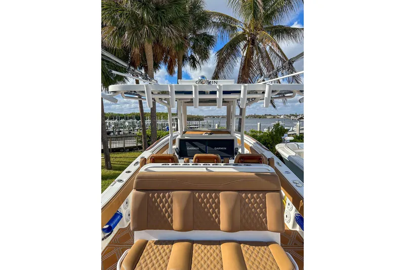Slide: The Image of 2022 Invincible 39 Open Fisherman boat with tan seating, docked near palm trees and water. - 7