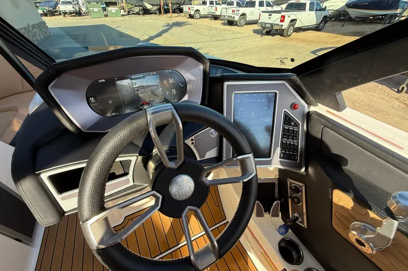 Slide: The Image of 2023 MasterCraft X22 boat dashboard with modern steering and digital controls. - 10