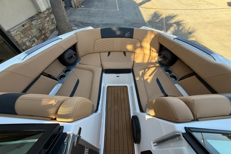 Slide: The Image of Luxurious seating area on 2023 MasterCraft X22 boat with tan upholstery and cup holders. - 12