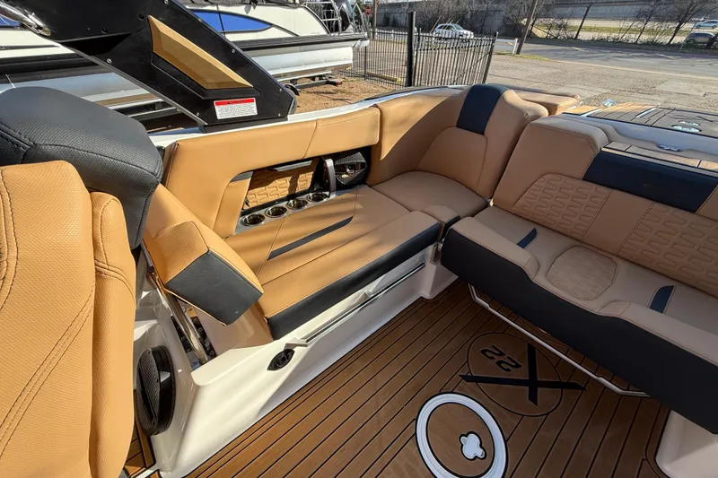Slide: The Image of 2023 MasterCraft X22 boat interior with tan leather seating and wood flooring. - 14