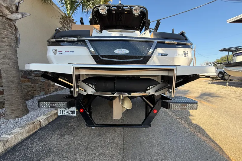 Slide: The Image of 2023 MasterCraft X22 boat rear view with trailer, parked outdoors. - 4
