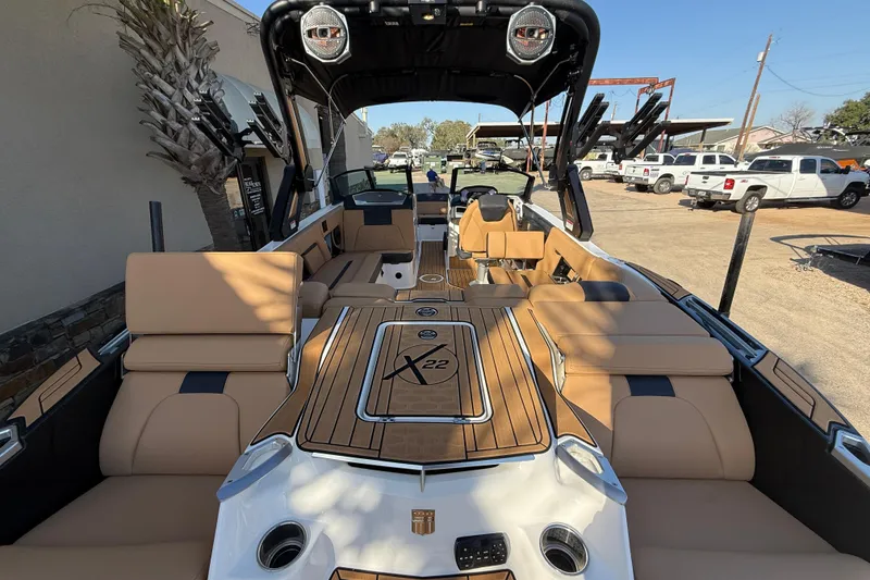 Slide: The Image of 2023 MasterCraft X22 boat interior with tan seating and sleek design. - 7