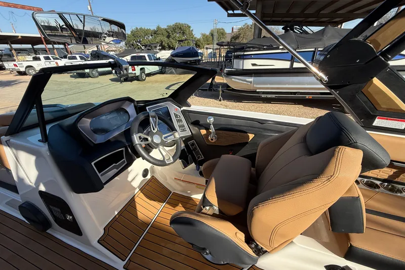 Slide: The Image of 2023 MasterCraft X22 boat interior with modern dashboard and tan seating. - 9