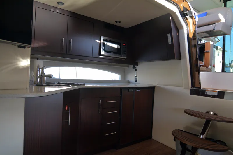 Slide: The Image of Interior of 2018 Regal 46 Sport Coupe yacht kitchen with modern cabinetry and appliances. - 16