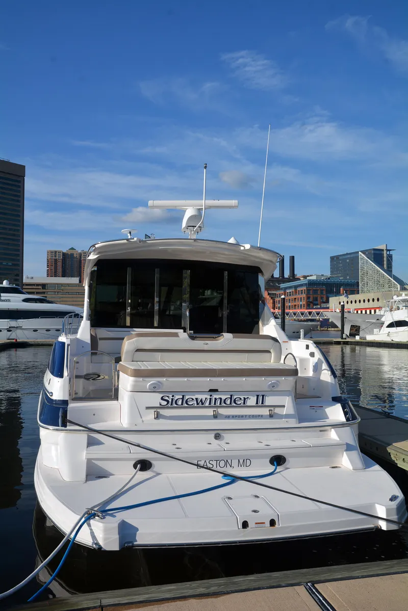 Slide: The Image of 2018 Regal 46 Sport Coupe yacht docked in a marina, clear sky background. - 7