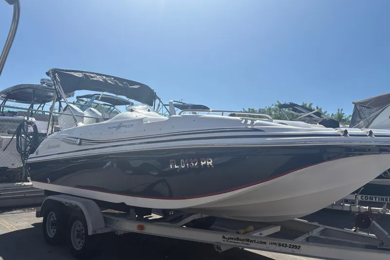 The Image of 2013 Hurricane SunDeck Sport 188 OB boat on trailer under clear blue sky. - 1