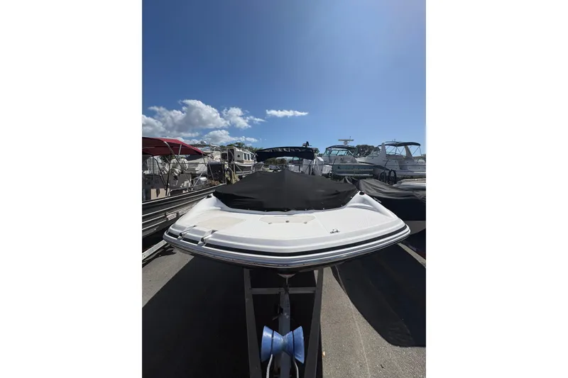 Slide: The Image of 2013 Hurricane SunDeck Sport 188 OB boat with cover, parked under clear blue sky. - 14