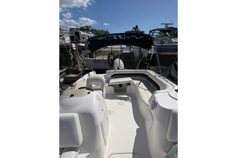 Slide: The Image of 2013 Hurricane SunDeck Sport 188 OB boat with seating and canopy, docked outdoors. - 7