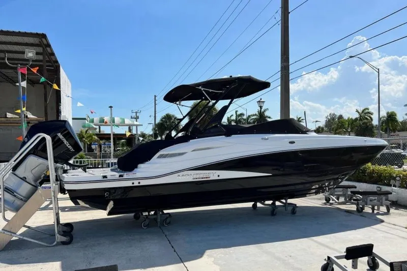 Slide: The Image of 2022 Monterey M-65 boat with Mercury engine, displayed outdoors under clear blue sky. - 1