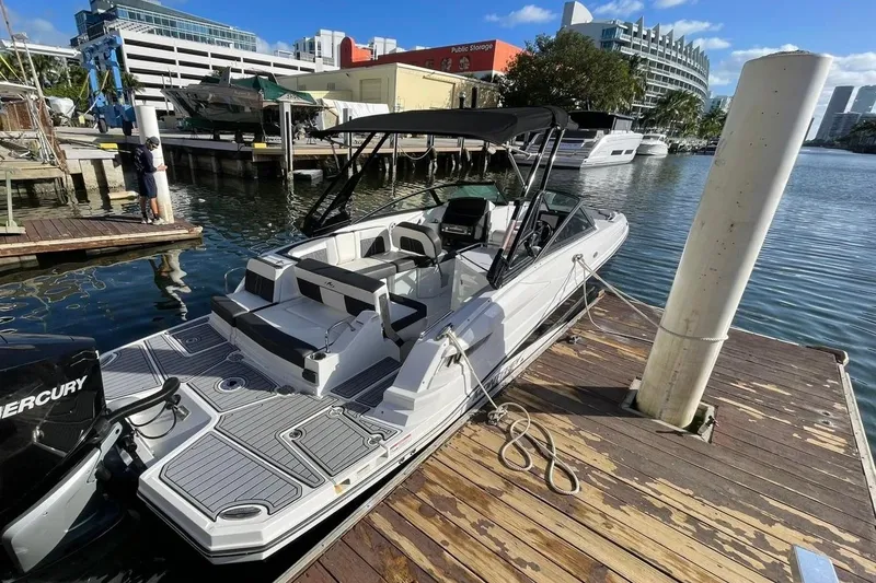 Slide: The Image of 2022 Monterey M-65 boat docked at marina, featuring sleek design and spacious seating. - 2